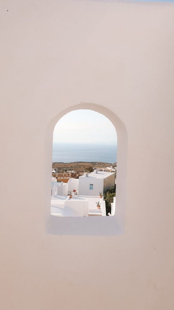 View of the Santorini countryside through a framed window.